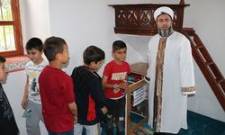 Köy imamı camiye gelen çocuklara ikramda bulunup birlikte oyun oynuyor