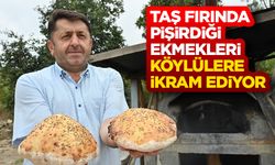 İmam taş fırında pişirdiği ekmekleri köylülere ikram ediyor