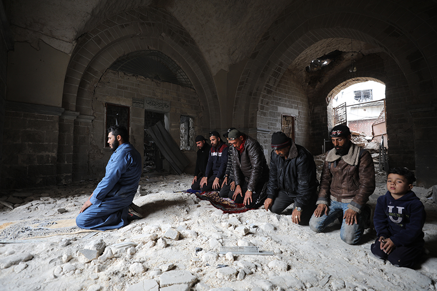 İmam Arif, caminin enkazında hoparlör olmadan ezan okuyarak halkı namaza çağırıyor.